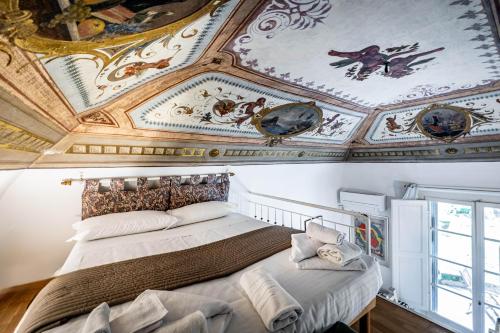 a bedroom with a ceiling with paintings on it at Roommo Pergola in Florence
