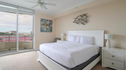 ein weißes Schlafzimmer mit einem großen Bett und einem Fenster in der Unterkunft Ocean Club 308 in Biloxi