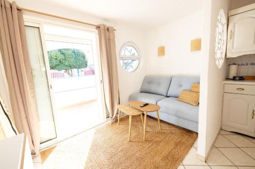 a living room with a couch and a table at Résidence Marie-Thérèse in Le Grau-du-Roi