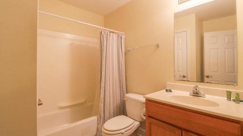 a bathroom with a toilet and a sink and a mirror at Oak Shores Studio 39 in Biloxi