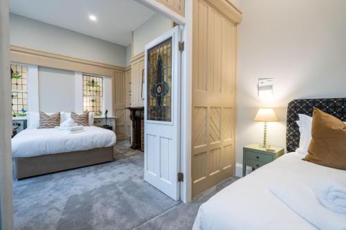 a bedroom with two beds and a door with a desk at Old Abbey House in Abingdon