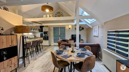 een keuken en een woonkamer met een tafel en stoelen bij Le Chalet de la Combe Sainte-Anne in Selongey