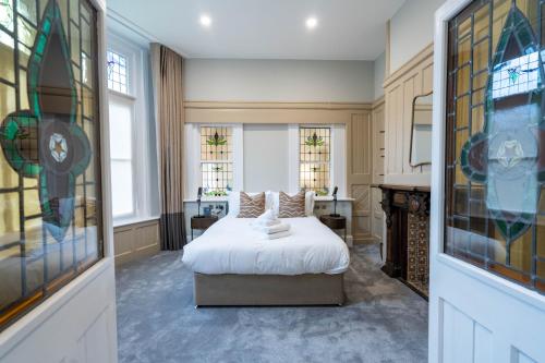 a bedroom with a bed and some windows at Old Abbey House in Abingdon