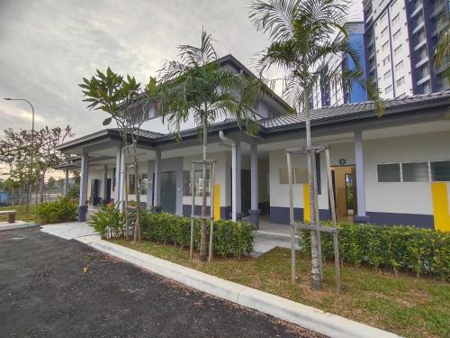 a building with palm trees in front of a street at QM Homestay in Semenyih