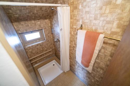a bathroom with a shower with an orange towel at Chasa Muglinér 115 in Scuol