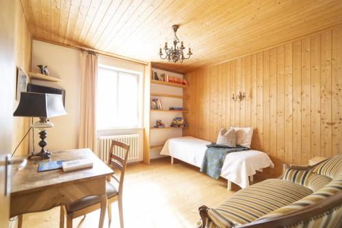 a bedroom with a bed and a desk and a table at Chasa Muglinér 115 in Scuol