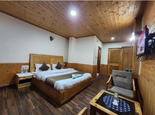 a bedroom with a bed and a tv and a chair at Hotel Ocean View By WB in Candolim
