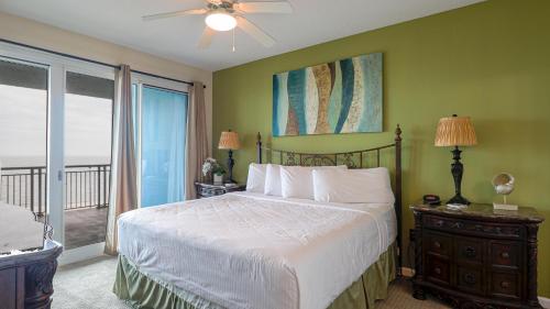 a bedroom with a white bed and a balcony at Legacy II 403 in Gulfport