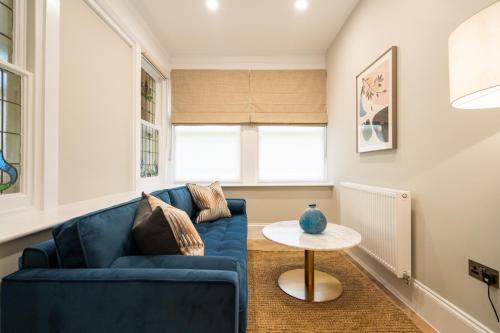 a living room with a blue couch and a table at Old Abbey House in Abingdon