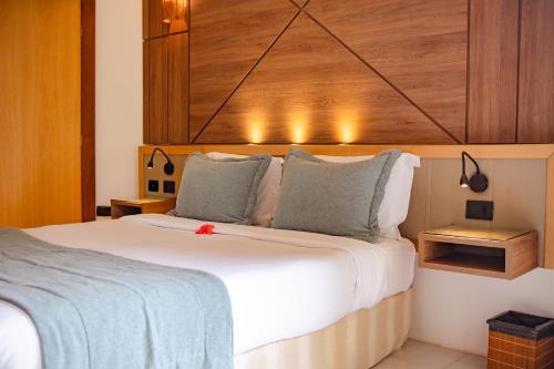 a bedroom with a large white bed with a wooden headboard at Pousada da Torre in Morro de São Paulo