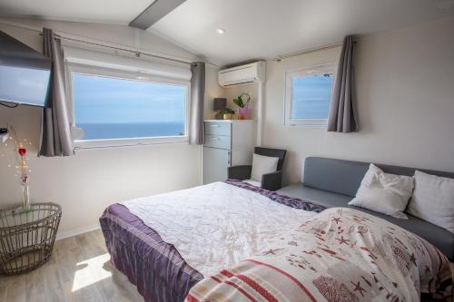 une chambre avec un lit et deux fenêtres dans l'établissement Paradis bleu et ile d'or, à Saint-Raphaël