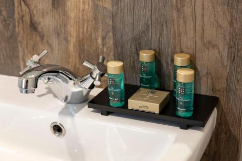a bathroom sink with two bottles ofodorizers on a shelf at Ribble Valley Country and Leisure Park 