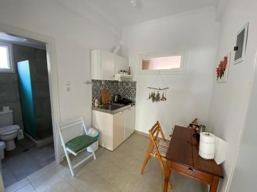 a kitchen with a sink and a table and a desk at Delikos House in Limenaria