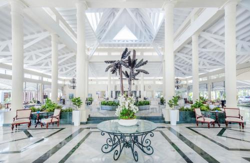 a lobby with a table and chairs and a palm tree at Bahia Principe Grand El Portillo - All Inclusive in Las Terrenas