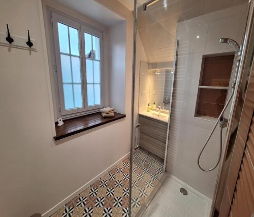 baño con ducha, lavabo y ventana en La Jacquerie en Baye