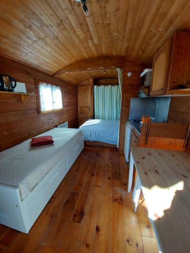 a bedroom with two beds in a wooden cabin at Les Roses de Jonzac in Mortiers