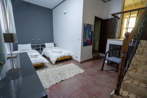 - un salon avec 2 lits et un escalier dans l'établissement Villa Enya Élégance&Authenticité, à Tanger
