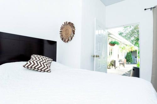 a bedroom with a white bed with a black headboard at Habitación Deluxe Tierra - Villa Valle Campo 