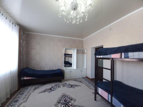 a bedroom with two bunk beds and a chandelier at Askar Guesthouse in Karakol