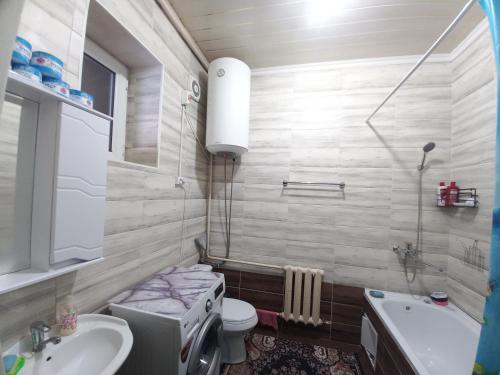 ein Badezimmer mit einem Waschbecken, einem WC und einer Badewanne in der Unterkunft Askar Guesthouse in Karakol