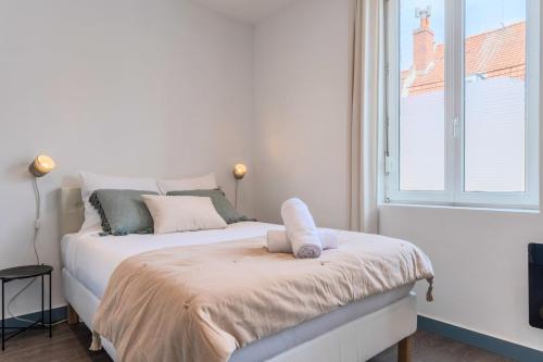 a white bedroom with a bed with a window at 3 bedroom house with terrace near Lille in La Madeleine