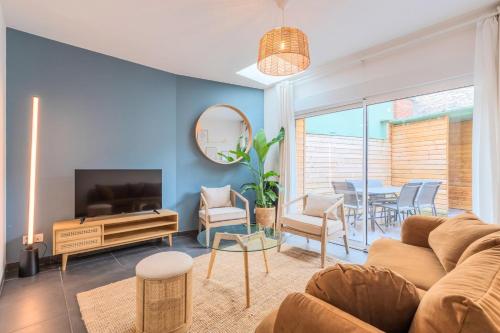 a living room with a couch and a tv and a table at 3 bedroom house with terrace near Lille in La Madeleine