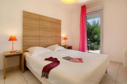 Un dormitorio con una gran cama blanca y una ventana en Vacancéole - Résidence Cap Camargue, en Le Grau-du-Roi