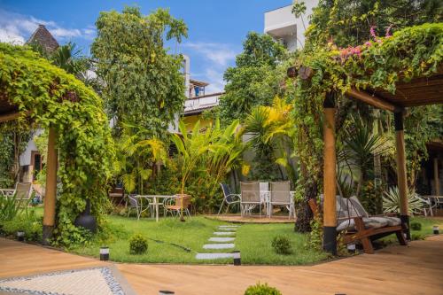 a garden with a table and chairs on the grass at Pousada da Torre in Morro de São Paulo