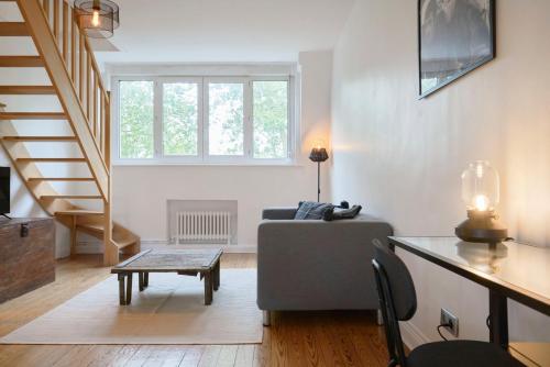 a living room with a couch and a stair case at Superbe appartement art deco tout équipé pour 2 ! in Marcq-en-Baroeul