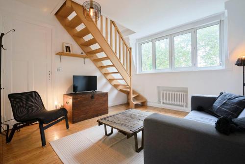 un salon avec un canapé et un escalier dans l'établissement Superbe appartement art deco tout équipé pour 2 !, à Marcq-en-Barœul