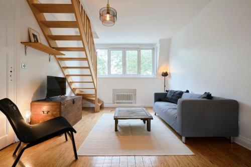 a living room with a couch and a staircase at Superbe appartement art deco tout équipé pour 2 ! in Marcq-en-Baroeul