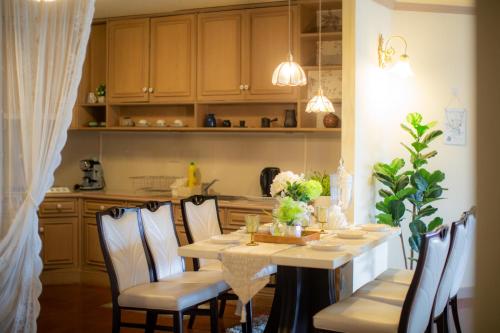 a dining room with a table with chairs and a kitchen at Secret garden in Chiang Mai