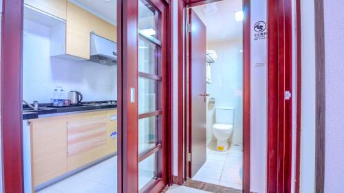 広州市にあるPazhou Yi Xiu Boutique Apartmentの赤いドアとトイレ付きのバスルームが備わります。