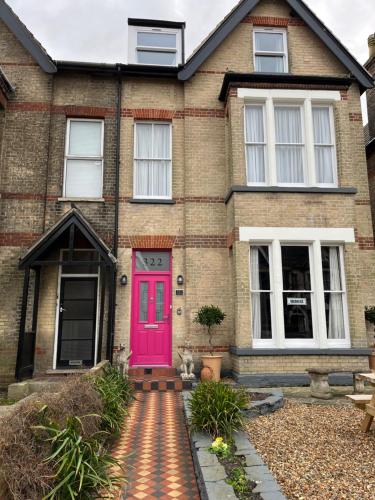 una casa de ladrillo con una puerta delantera rosa en Most Easterly, en Pakefield