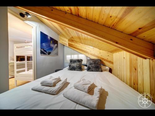 1 dormitorio con 1 cama blanca grande y techos de madera en CIGALERA de Alma de Nieve, en Naut Aran (Alto Arán)