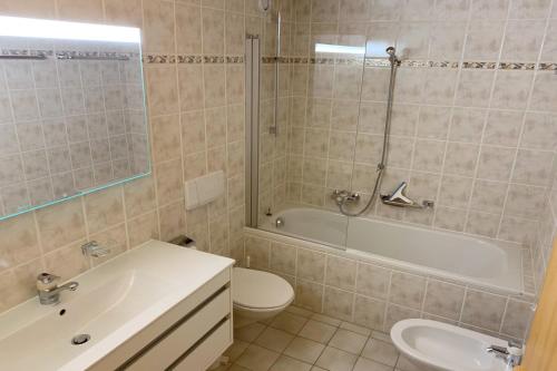łazienka z wanną, toaletą i umywalką w obiekcie Amadeus 132 w mieście Verbier