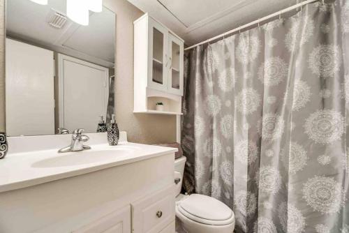 a bathroom with a sink and a toilet and a shower curtain at I12 - DFW Grd Flr Modern Furn. Condo 2BD1BA in Irving