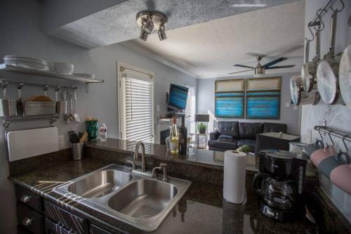 a kitchen with a sink and a living room at I14 - DFW Condo Near Baylor 2BD/1BA in Irving