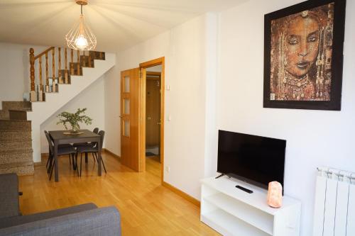 een woonkamer met een flatscreen-tv en een tafel bij 33 Pasos Catedral 3 in León