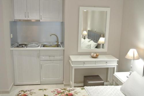 a white kitchen with a sink and a mirror at luxury studios ath in Limenas