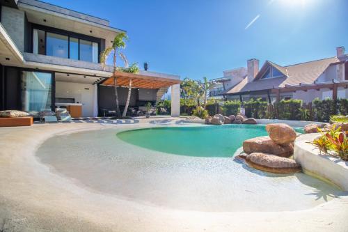 uma piscina no quintal de uma casa em Casa incrível c/spa e praia artificial particular! em Xangri-lá