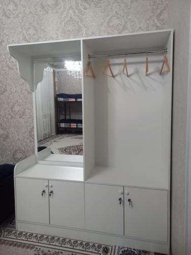 a white dresser with a mirror in a room at Askar Guesthouse in Karakol