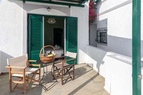 a table and chairs on a porch with a basket of fruit at Triton Authentic Cretan Hotel in Tsoútsouros