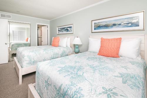 Ocean City Beach Retreat with Linens Included في آوشين سيتي: سريرين في غرفة مع سريرين sidx sidx sidx sidx