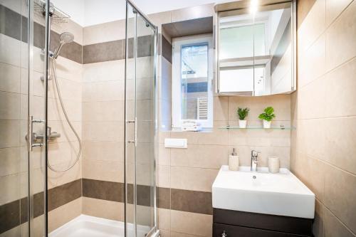 uma casa de banho com um lavatório e um chuveiro em Studio Apartman Lena em Rijeka