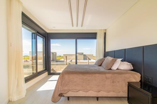 sypialnia z łóżkiem i dużym oknem w obiekcie Casa incrível c/spa e praia artificial particular! w mieście Xangri-lá