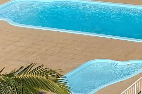 uma vista superior de uma piscina ao lado de uma praia em Espaçoso & Aconchegante AP - Até 10 pessoas. em Santa Cruz do Sul