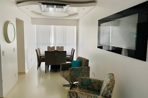 ein Wohnzimmer mit einem Tisch und Stühlen sowie ein Esszimmer in der Unterkunft Espaçoso & Aconchegante AP - Até 10 pessoas. in Santa Cruz do Sul