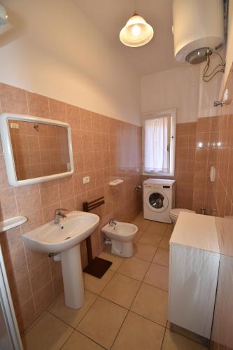 a bathroom with a sink and a toilet at Bilocale Lavanda - 100 mt. dal mare con clima in Marina di Campo
