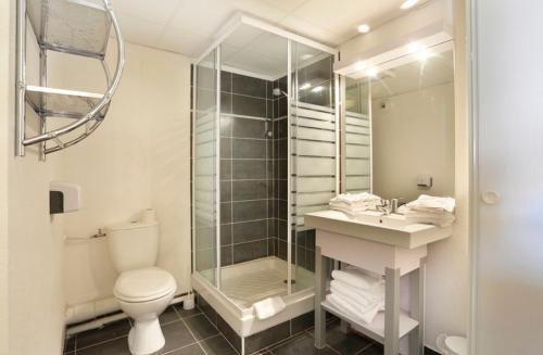 a bathroom with a shower and a toilet and a sink at Vacancéole - Résidence Cap Camargue in Le Grau-du-Roi